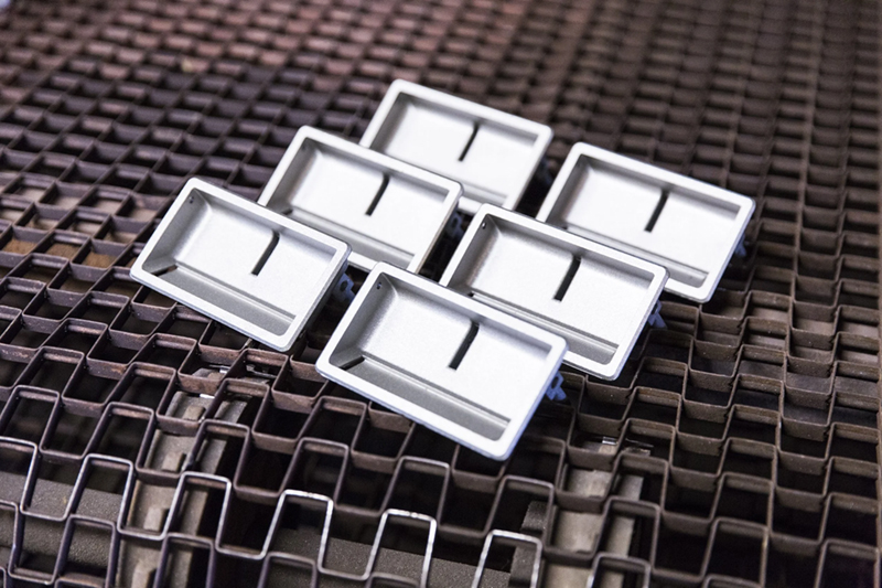 Six rectangular metal trays with a central slot are arranged in a cluster 